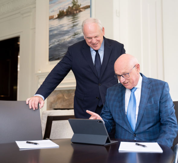 Joe Pal and Jeff Shaddick in Pal Insurance office looking at tablet